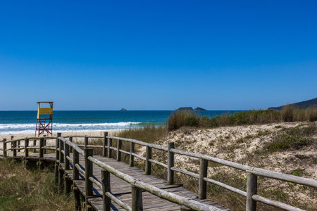 An old boardwalk to the beach under a bright skyの写真素材