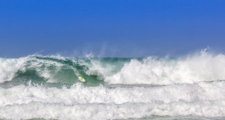 A surfboard on sea waves under a bright sky