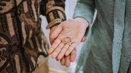 A closeup of a young couple holding engagement rings on their palms