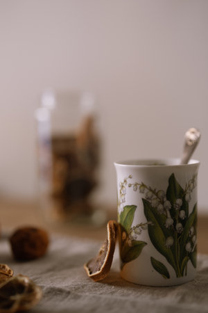 A vertical selective focus of dried lemon tea in a white mug on a fabric surfaceの写真素材