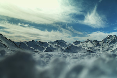 A chilling view of snowy mountainous landscape in the Ischgl, Austria under a wispy sky backgroundの写真素材
