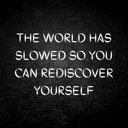 A white quote reading "The world has slowed so you can rediscover yourself" on the black backgroundの写真素材