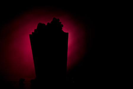 A closeup shot of a silhouette of popcorn with a dark red backgroundの写真素材