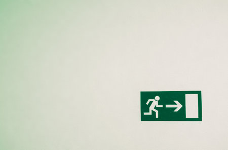 An emergency exit sign on a white wallの写真素材
