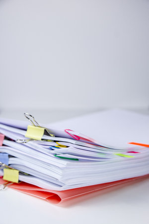 Close-up of a set of sheets attached by clips and clamps. Vertical photography. Information overload conceptの写真素材