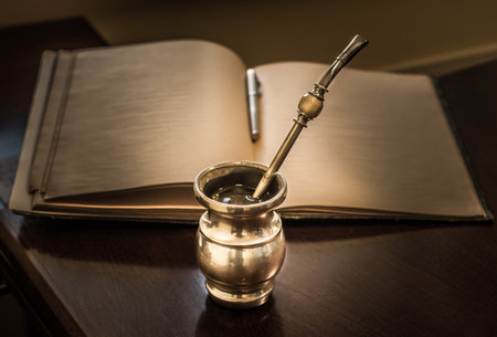 A selective focus shot of yerba mate, in front of a pen and notebook