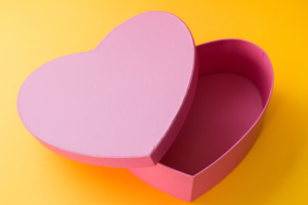 A Valentine's Day gift box in a heart shape isolated on a yellow backgroundの写真素材