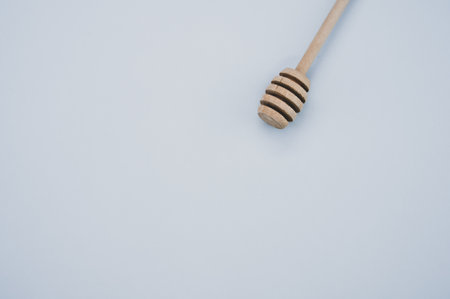 A high angle shot of a wooden honey dipper on a grey surfaceの写真素材