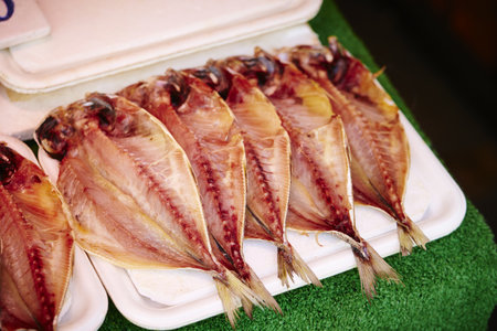 A closeup of delicious dried fish on white trays