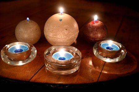 A closeup shot of candles on a wooden taの写真素材