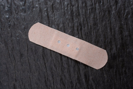 A closeup shot of a patch medical band on a dark rough surfa