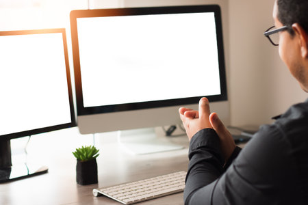 A closeup shot of a man in glasses working with a computer at home