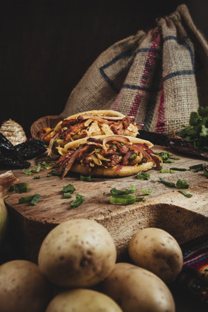 A closeup shot of delicious Mexican tacos with beef, cheese and vegetables on a chopping boardの写真素材