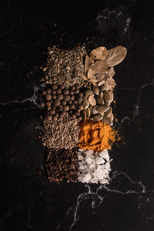 A vertical shot of spices and seeds on black backgroundの写真素材