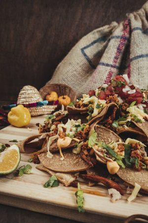 A closeup shot of traditional Mexican nachos with beef, cheese, vegetables, tortilla chips and limeの写真素材