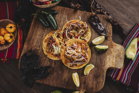 A high angle shot of delicious Mexican tacos with chili pepper, lime and beef on a chopping boardの写真素材