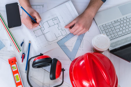 An Architectural contractor, engineer, architect doing blueprint design with tools on the tableの写真素材