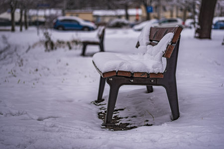 Snow covered bench in winterの写真素材