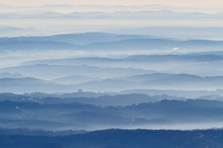 Dust, smoke and smog in the air above a hill landscape around Graz in Austriaの写真素材