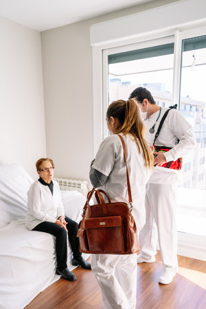 T doctors make an emergency visit to an elderly woman during the covid pandemicの写真素材