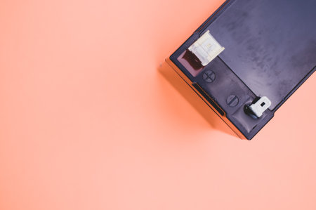 An overhead partial view of a UPS battery replacement cartridge on an orange surface with space for your textの写真素材