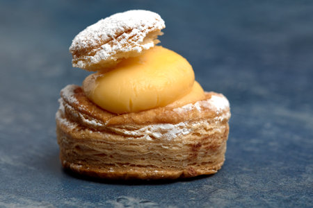 A closeup of a delicious fluffy cake with custard and a sugar powder topping on the tableの写真素材