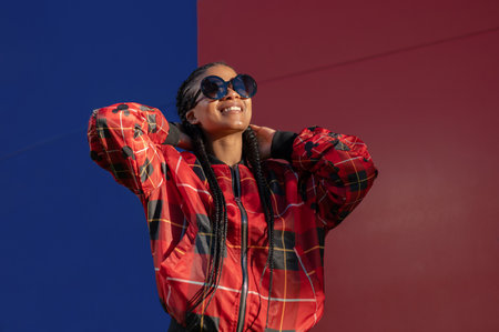 A beautiful Afro-American female wearing sunglasses and enjoying the sunlightの写真素材