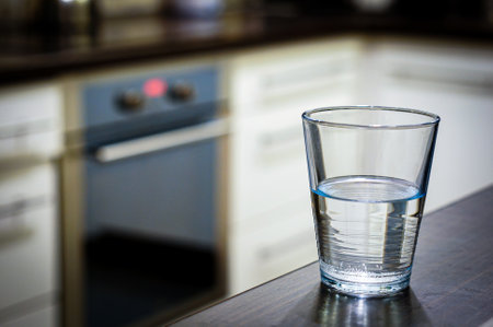 A selective focus shot of a glass of water on wooden tableの写真素材