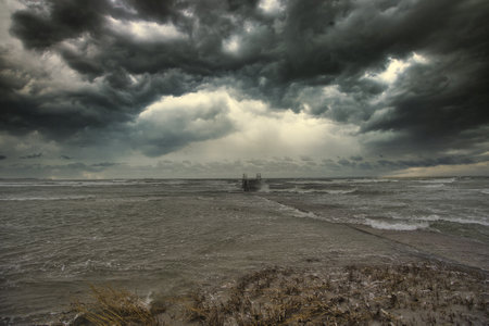 The dramatic stormy clouds in the sky above the seの写真素材