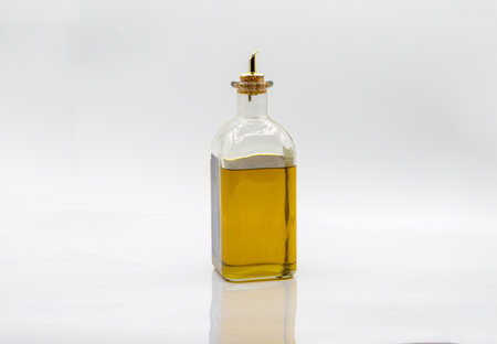 A closeup shot of olive oil in a glass bottle isolated on white backgroundの写真素材