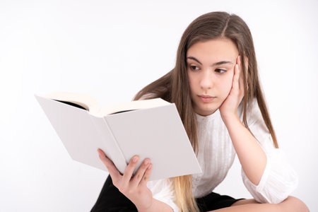 A beautiful young lady reading a book wearing a black skirt and white blouse