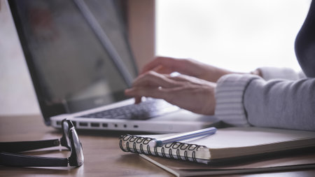 A female typing on a laptop while working from home