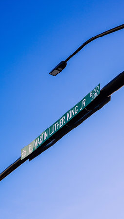A vertical low angle shot of a road sign under a blue clear skyの写真素材