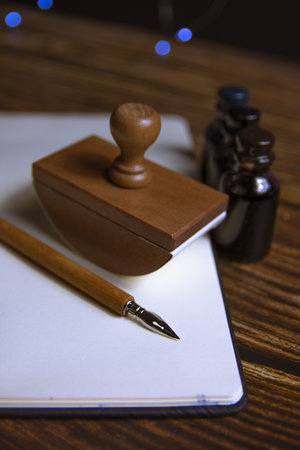 Close-up of a fountain pen on a notebook and several inkwells.の写真素材