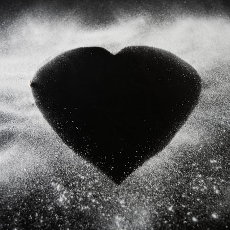 A closeup shot of a black heart shape with white powder on the sidesの写真素材