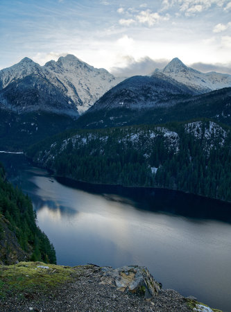 A serene view of a river flowing between magnificent mountains