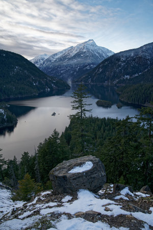 A vertical serene view of a river flowing between magnificent mountainsの写真素材
