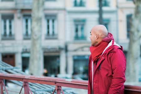 A bald Latin male walking wearing a red coatの写真素材