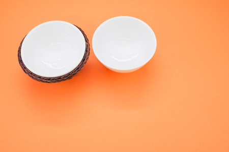 A closeup shot of soup bowls isolated on an orange backgroundの写真素材