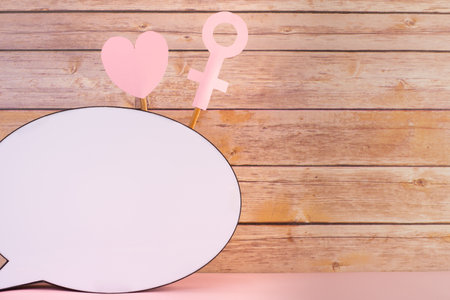 A closeup of copy space for the text with a heart and a female gender sign on wooden backgroundの写真素材