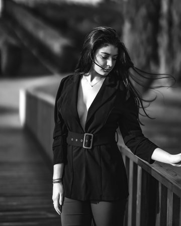 A vertical grayscale shot of a young attractive Caucasian woman posing