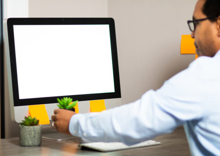 A closeup shot of a man in glasses working with a computer at homeの写真素材
