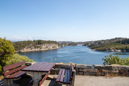 A scenic view of a bench and table at the viewpoint by the road in the beautiful fjord in Norway