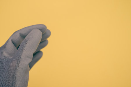 A closeup shot of a working glove on a yellow backgroundの写真素材