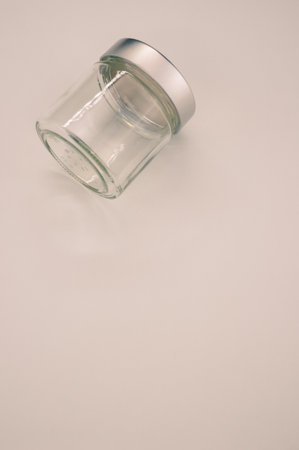 A vertical shot of a glass jar on a gray background