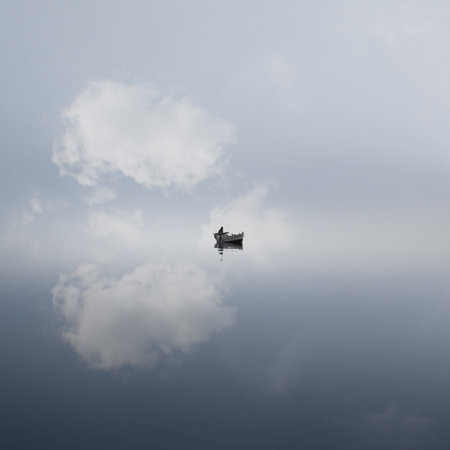 A fisherman on a boat on the sea with long exposure and a blue sky reflecting on itの写真素材