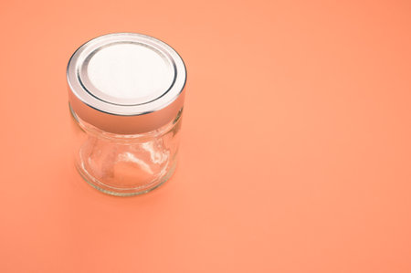 A closeup shot of a glass jar on an orange background