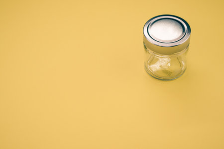 A closeup shot of a glass jar on a yellow backgroundの写真素材