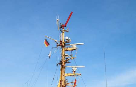 A closeup shot of a ship mast with a German flag against the blue skyの写真素材