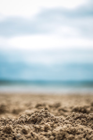 A selective focus shot of wet sand on the coastの写真素材